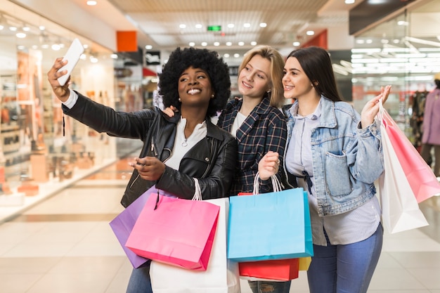 Foto gratuita grupo de mujeres tomando una selfie después de ir de compras