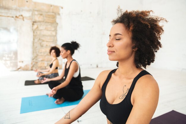 Grupo multicultural haciendo ejercicios de yoga en colchonetas