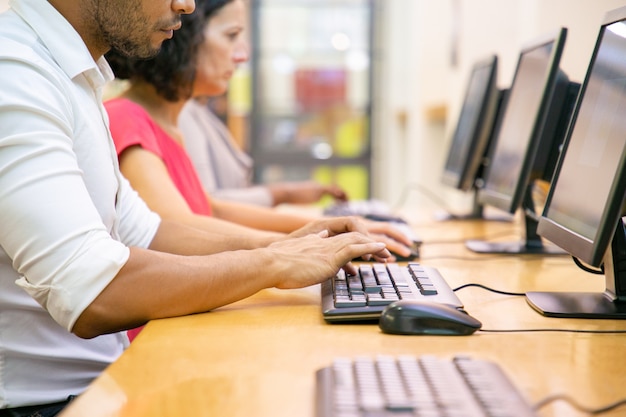 Grupo multiétnico de alumnos trabajando en clase de informática