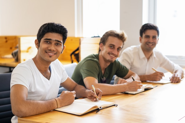 Grupo multiétnico de estudiantes felices posando en el aula