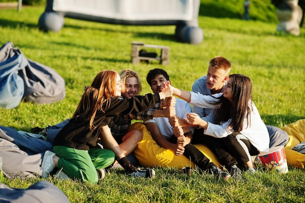 Grupo multiétnico joven de personas viendo películas en poof en cine al aire libre