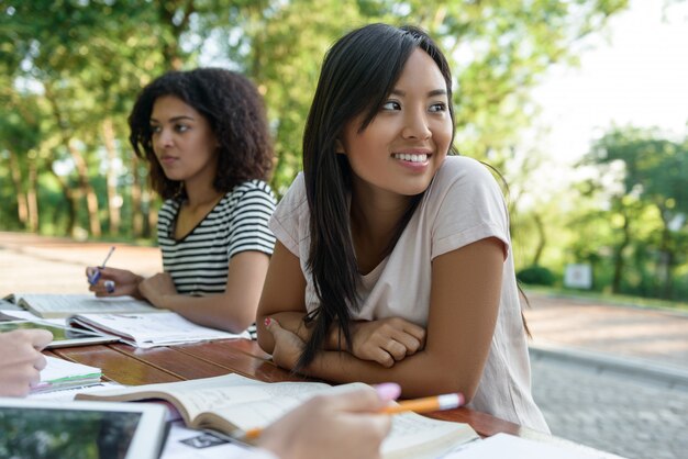 Grupo multiétnico de jóvenes estudiantes sentados y estudiando