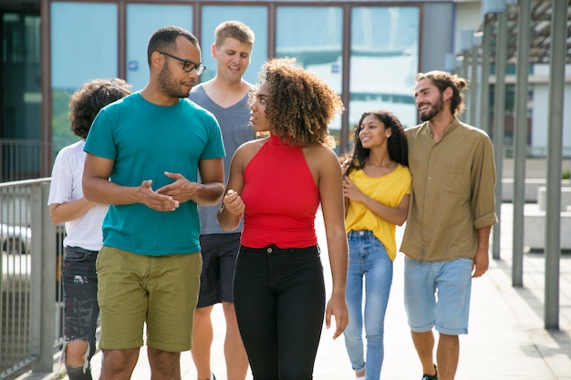 Grupo multiétnico de personas en caminatas casuales en entornos urbanos.