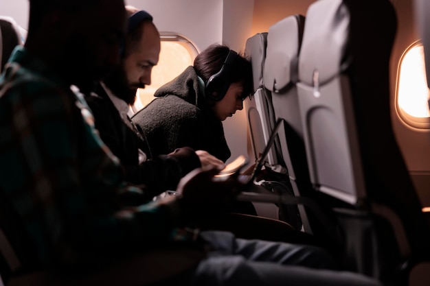 Grupo multiétnico de turistas que viajan en vuelos comerciales con servicio de vías aéreas internacionales. Volar en avión durante la puesta de sol para llegar al destino de la aerolínea, sintiéndose asustado por el despegue.