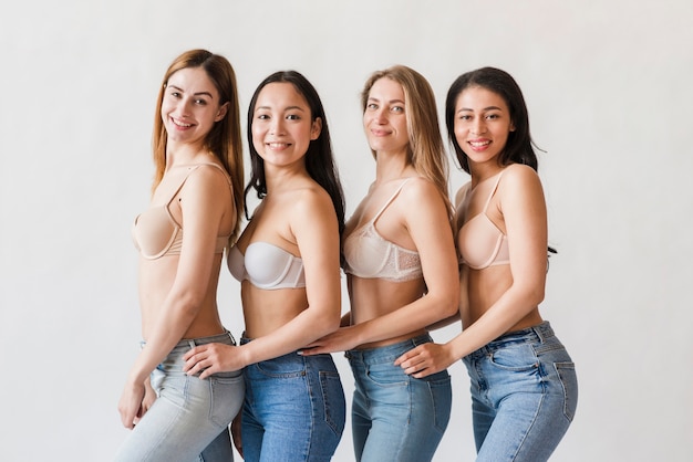 Grupo multirracial de mujeres felices posando en sujetadores