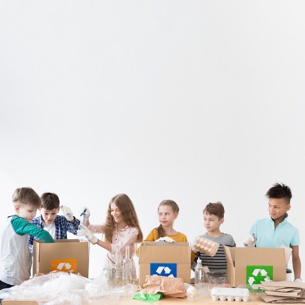 Foto gratuita grupo de niños aprendiendo a reciclar