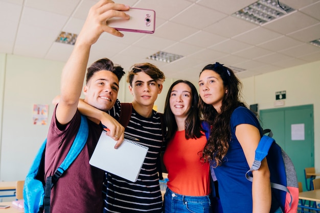 Grupo de niños de colegio haciendo un selfie en sala de clase