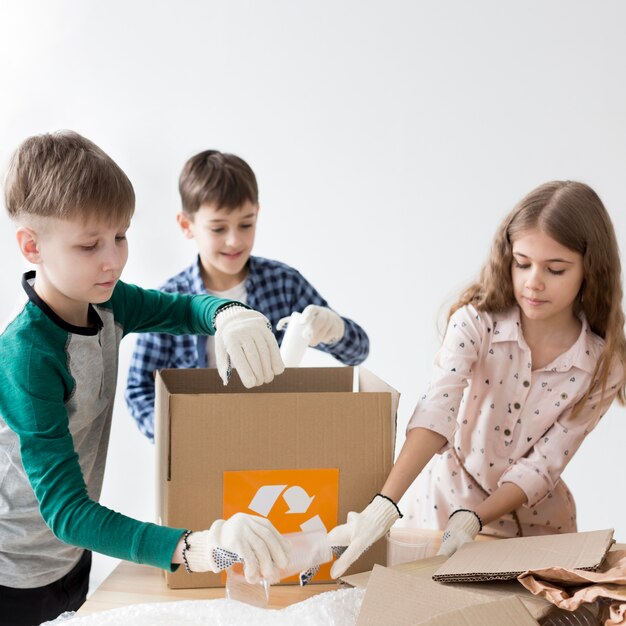 Grupo de niños felices aprendiendo a reciclar