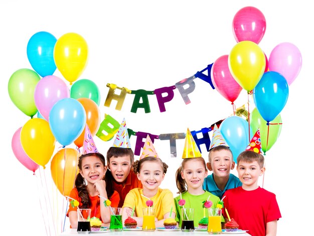 Grupo de niños felices en camisetas de colores que se divierten en la fiesta de cumpleaños - aislado en un blanco