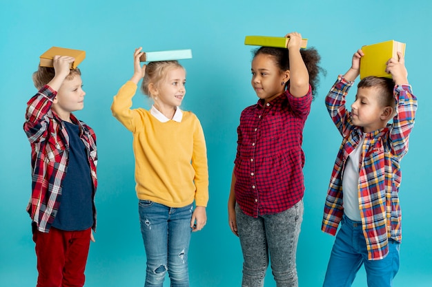 Grupo de niños con libros en la cabeza.