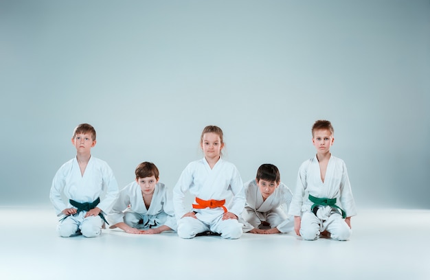 El grupo de niños y niñas que luchan en el entrenamiento de Aikido en la escuela de artes marciales. Estilo de vida saludable y concepto deportivo