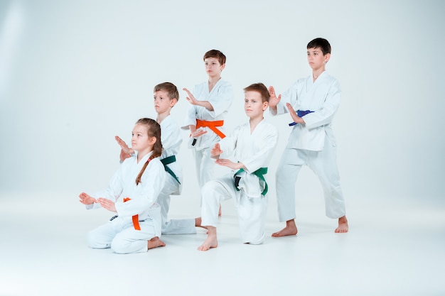 Grupo de niños y niñas que luchan en el entrenamiento de Aikido en la escuela de artes marciales. Estilo de vida saludable y concepto deportivo