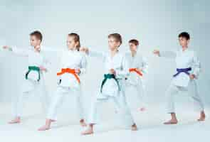 Foto gratuita el grupo de niños y niñas que luchan en el entrenamiento de aikido en la escuela de artes marciales. estilo de vida saludable y concepto deportivo