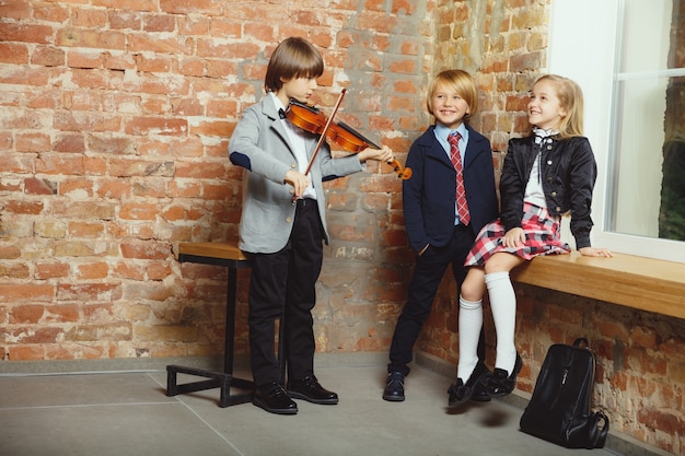 Grupo de niños que pasan tiempo juntos después de la escuela. Amigos guapos descansando después de clases antes de comenzar a hacer los deberes