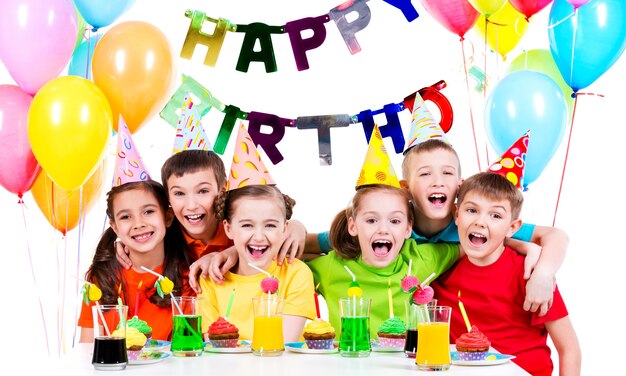 Grupo de niños riendo divirtiéndose en la fiesta de cumpleaños - aislado en un blanco.