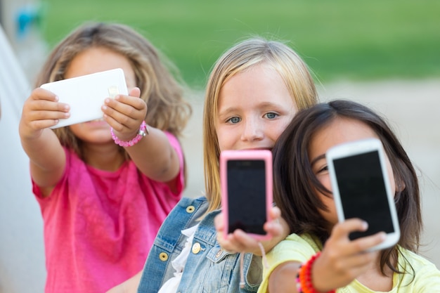 Foto gratuita grupo de niños tomando un selfie en el parque.