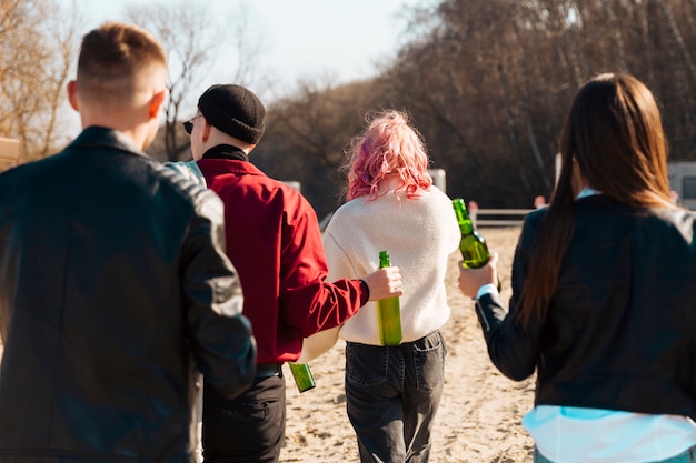 Grupo de personas caminando con botellas de cerveza