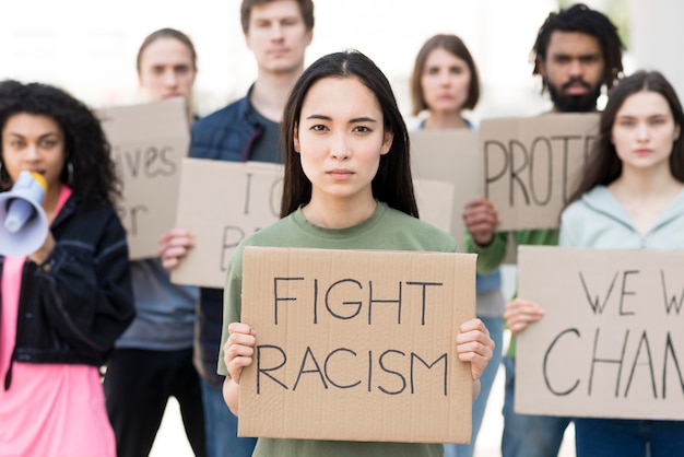 Foto gratuita grupo de personas con citas de lucha contra el racismo