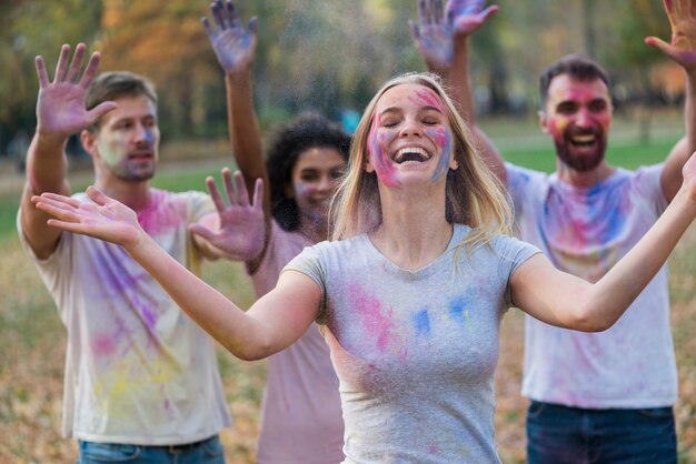 Grupo de personas cubiertas de pintura multicolor.