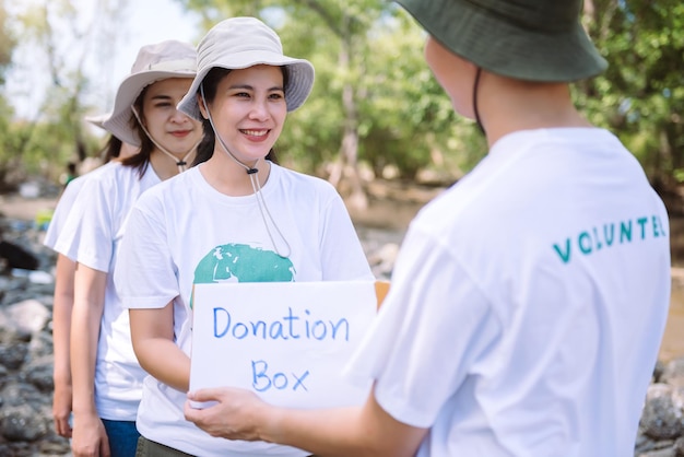 Foto gratuita grupo de personas diversas asiáticas voluntarias que sostienen una caja de donación para recaudar fondos para situaciones de emergencia, como ayudar a las víctimas de las inundaciones en ucrania, comida para niños, evento de caridad voluntariado conceptual