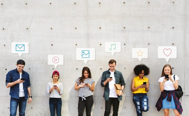 Grupo de personas diversas que usan sus teléfonos.