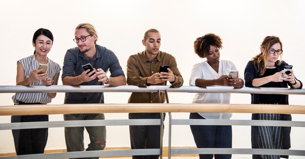 Grupo de personas diversas que usan teléfonos inteligentes