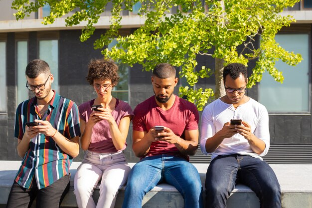 Grupo de personas enfocado en sus teléfonos inteligentes