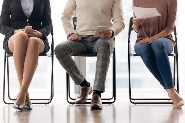 Foto gratuita grupo de personas esperando para una entrevista de trabajo, sentados en sillas