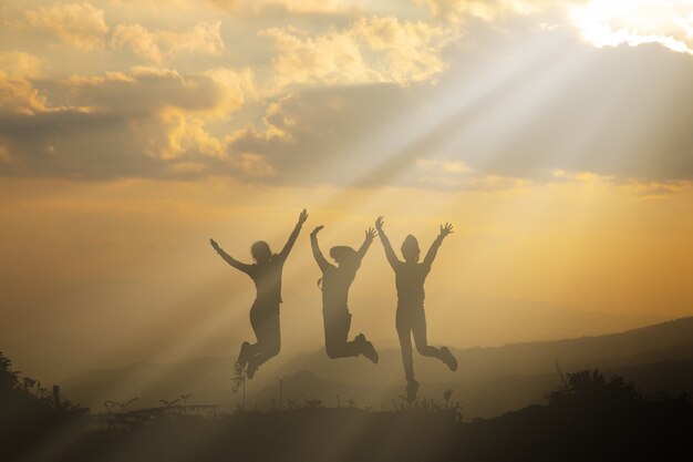 Grupo de personas felices jugando al atardecer de verano en la naturaleza