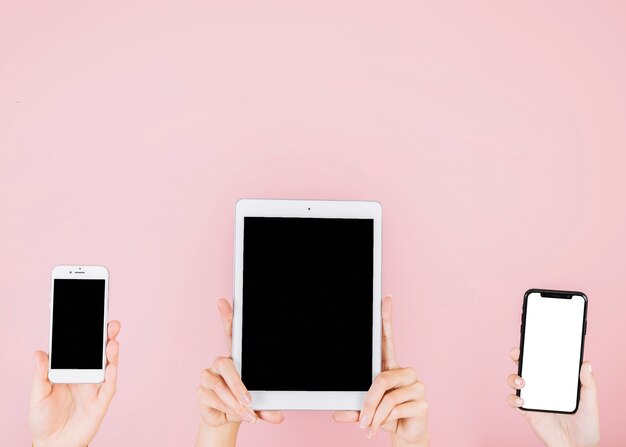 Grupo de personas con gadgets electrónicos sobre fondo rosa