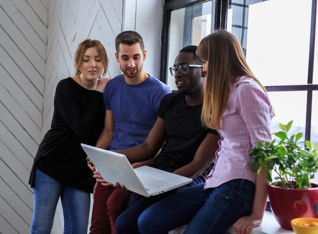 Un grupo de personas internacionales trabajando con una laptop.