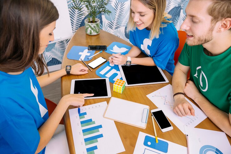 Foto gratuito grupo de personas mirando una tableta digital con iconos de redes sociales en el lugar de trabajo