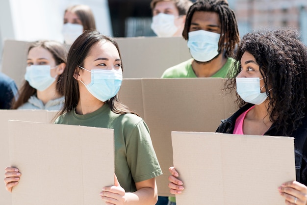 Grupo de personas protestando y con máscaras médicas