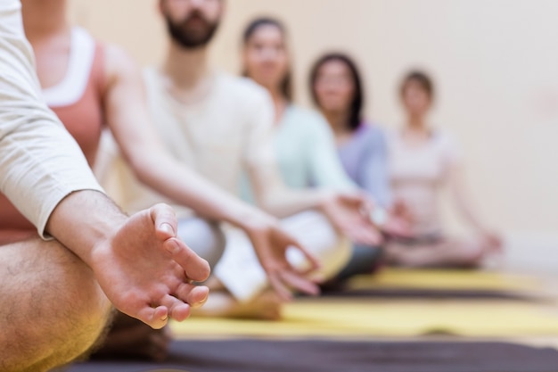 Grupo de personas que hace ejercicio de la meditación en la estera