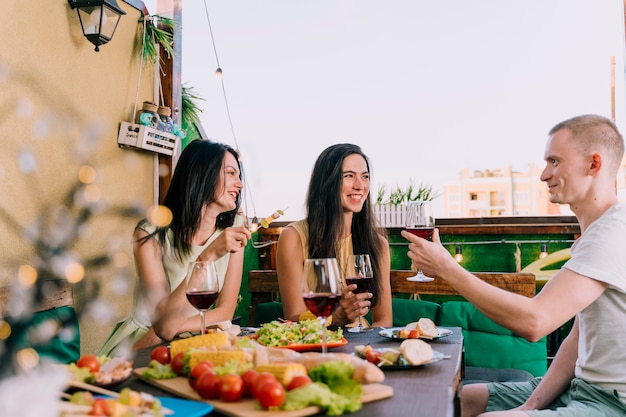 Grupo de personas que tuestan vino en la azotea