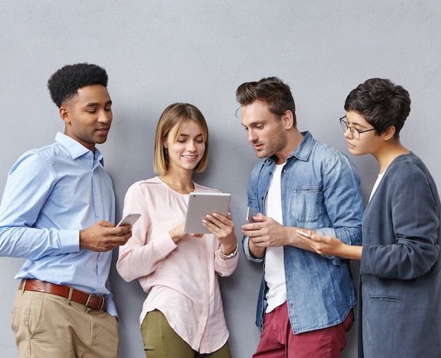 Grupo de personas con teléfonos inteligentes y tabletas.