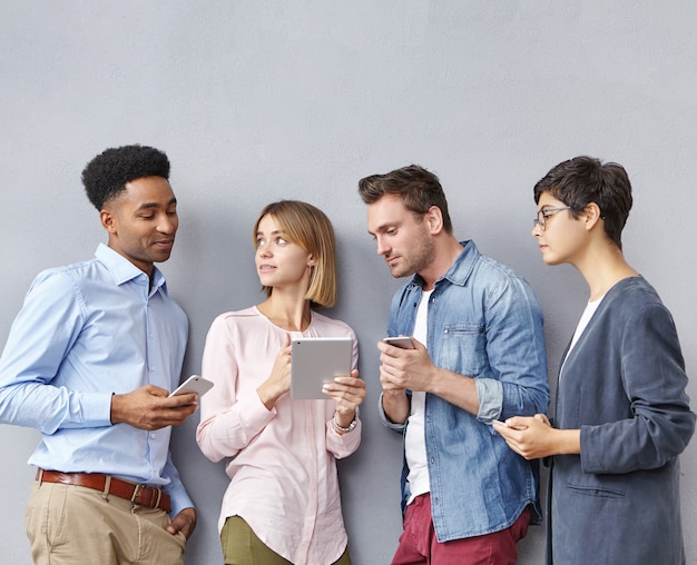 Grupo de personas con teléfonos inteligentes y tabletas.