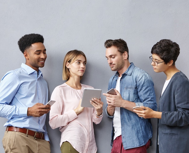 Grupo de personas con teléfonos inteligentes y tabletas.