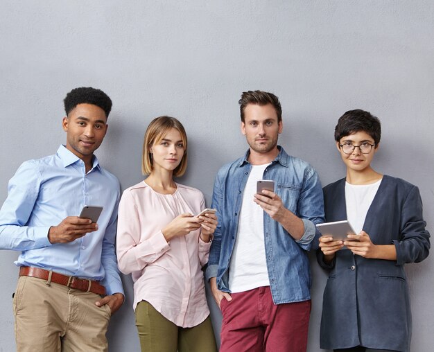Grupo de personas con teléfonos inteligentes y tabletas.