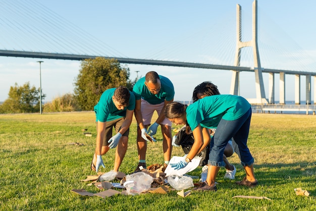 Grupo de trabajadores de limpieza recogiendo basura al aire libre