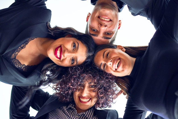 Grupo de trabajadores de negocios sonriendo felices De pie con las cabezas juntas abrazándose con una sonrisa en la cara en la oficina