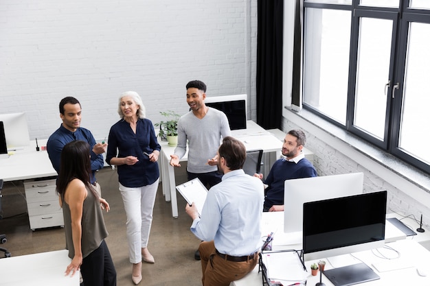 Grupo de trabajadores de oficina discutiendo ideas de negocio