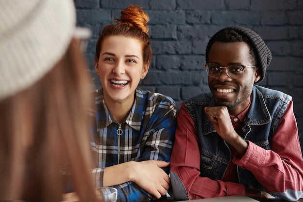 Foto gratuita grupo de tres estudiantes felices divirtiéndose en el interior