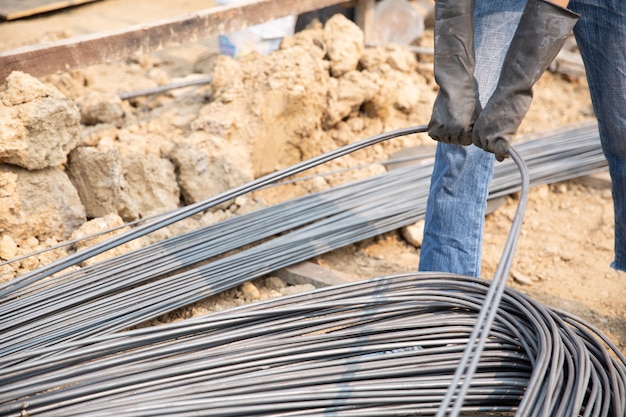 Un grupo de varillas de acero apretadas por la cadena y elevar en el sitio de construcción