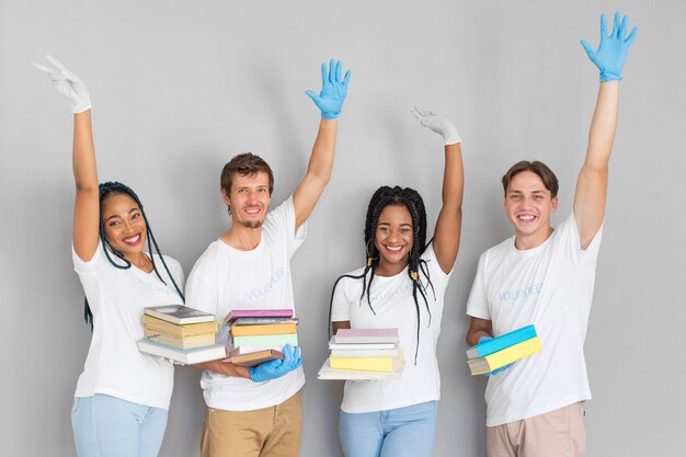 Grupo de voluntariado con libros para donaciones.