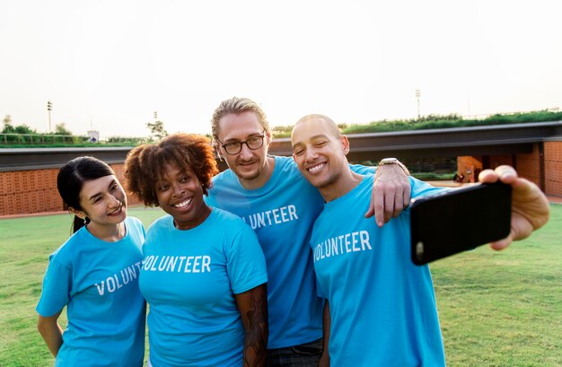 Grupo de voluntarios diversos que toman selfie juntos