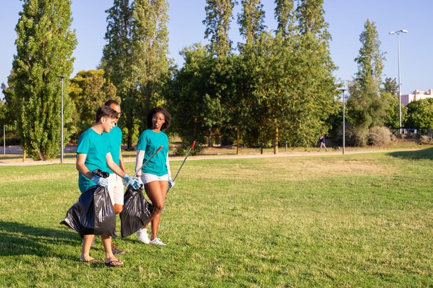 Grupo de voluntarios ecológicos que abandonan el parque después de limpiar el césped