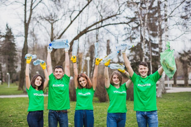 Grupo de voluntarios levantando botellas de plástico