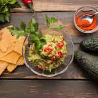 Foto gratuita guacamole entre nachos y pimentón con aguacate