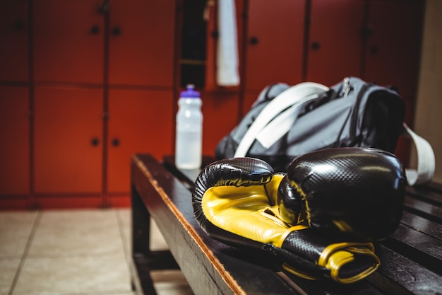 Guantes de boxeo en banco en vestuario